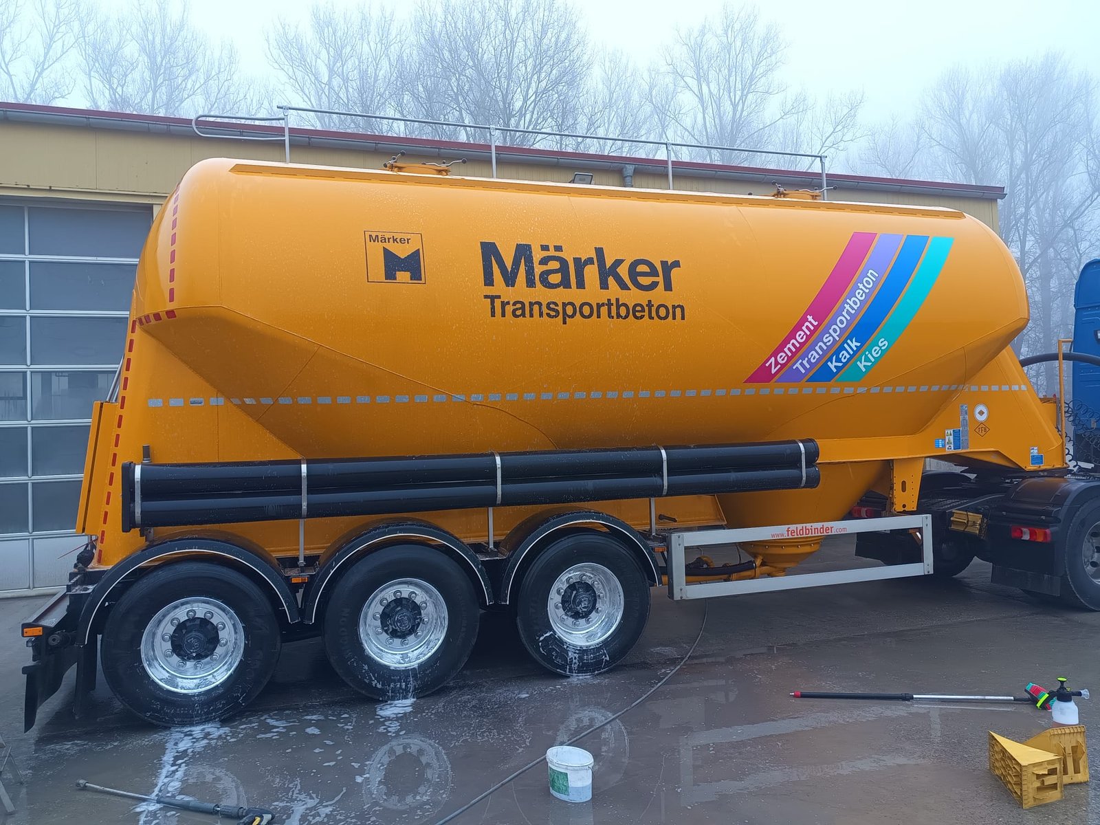Seitenansicht eines LKW mit Reinigungsschaum bei der Wäsche